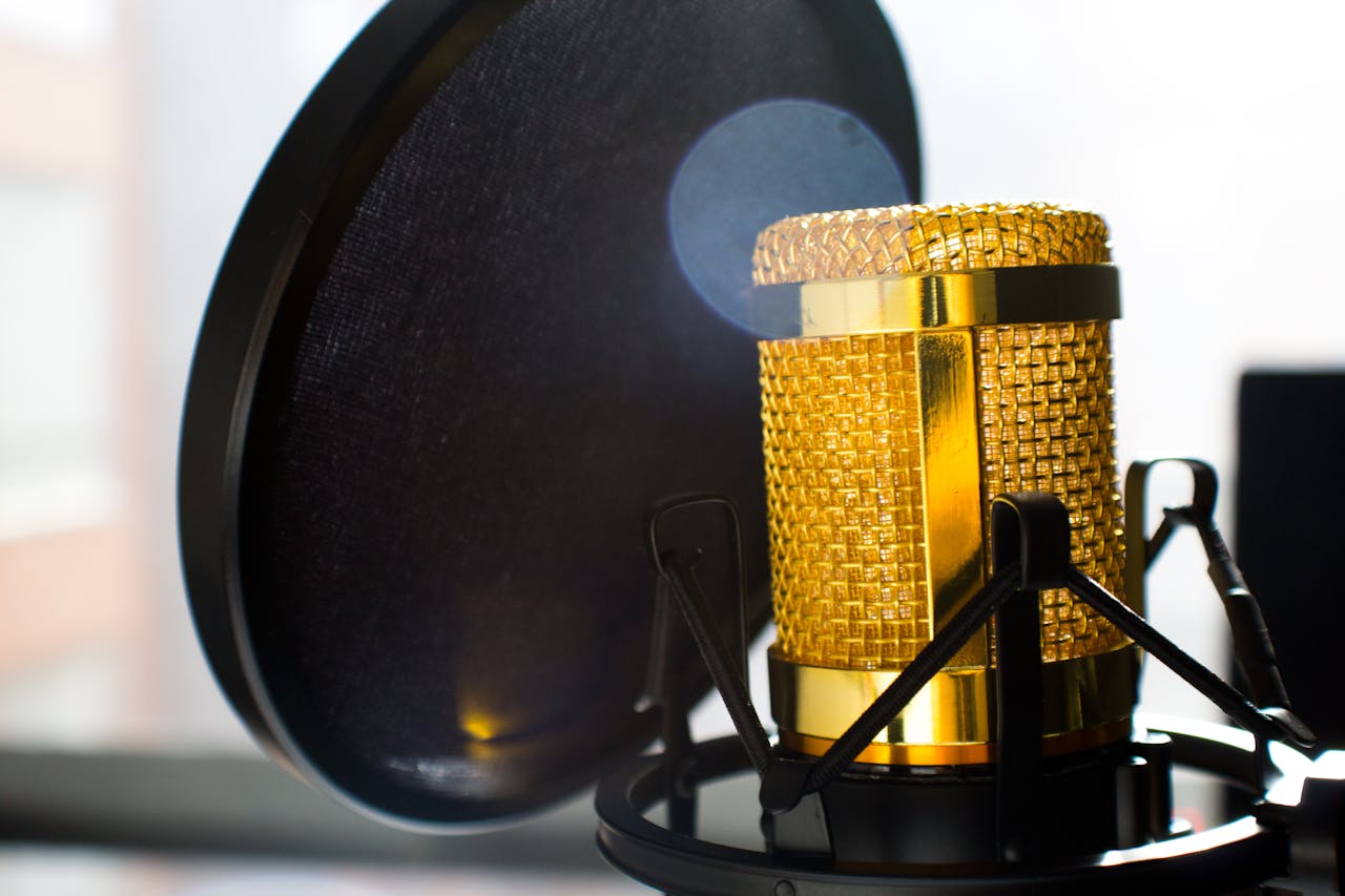 Les stars de la musique et leur impact sur la culture mondiale Close-up of a gold studio microphone with pop filter, ideal for recording and broadcasting.